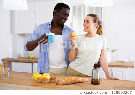 Positive couple having breakfast in kitchen at home 119903267