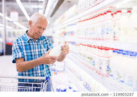 Old age man choosing milk in supermarket 119903287