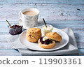 Cream tea with scones, afternoon tea, milk tea, jam on top, blue wood background 2 119903361