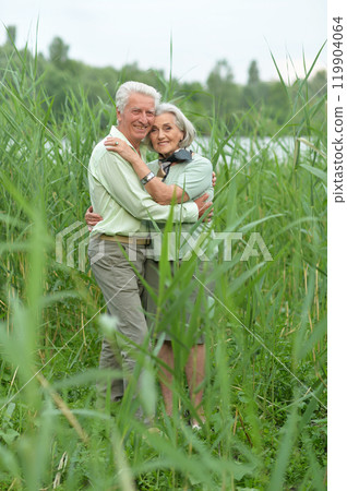 Beautiful senior couple relaxing and posing in the summer park 119904064
