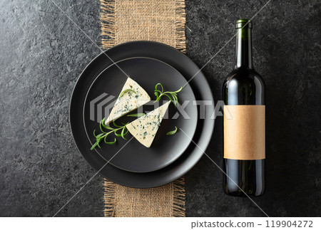 Bottle of red wine and blue cheese on a black plate. Bottle of red wine and blue cheese on a black plate. 119904272
