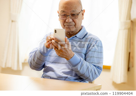 操作智能手機的老人 119904404