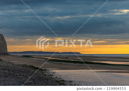 Tranquil beach scene with a golden sunset, calm waters, serene coastline, and dusk settling in 119904553