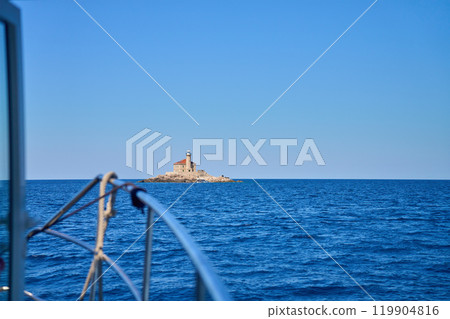 Sea landscape with lighthouse on tall rocky island in sea on sunny day 119904816