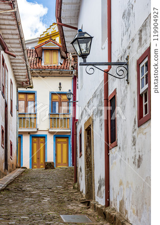 Alley with old colonial houses and stone paving 119904927
