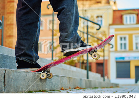 Close-up of skateboarder on pink skateboard at street 119905048