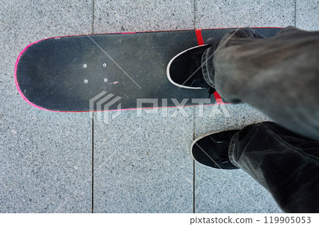 Top view of skateboarder riding on skateboard on road 119905053