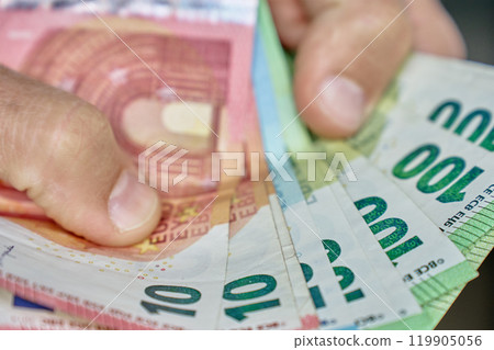 Hand Holding Euro Banknotes for Financial Transaction 119905056