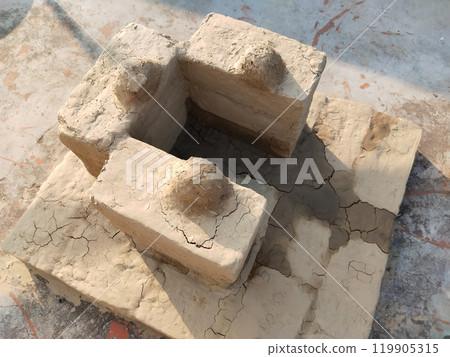 newly made soil stove. Traditional Indian earthen cooking stove Countryside clay stove, Indian rural person making stove with clay, way of making food on open fire in old Indian kitchen 119905315