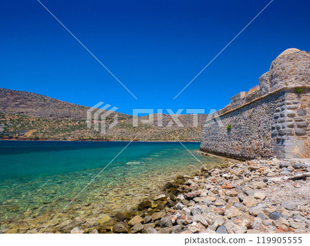 Calm and clear beach in front of the ruins (Spinalonga, Crete, Greece) Calm and clear beach in front of the ruins (Spinalonga, Crete, Greece) 119905555