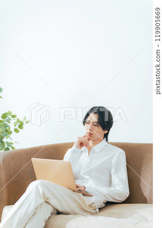 A man using a laptop in the living room A man using a laptop in the living room 119905669
