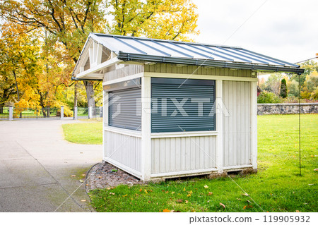 Closed wooden kiosk with metal blinds. Beautiful autumn day Closed wooden kiosk with metal blinds. Beautiful autumn day 119905932