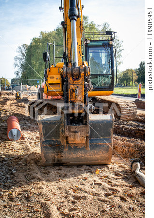 Huge yellow excavator with tracks and a bucket. Construction site and road construction 119905951