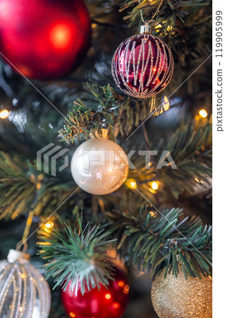 Christmas tree with red, gold and silver toys. Festively decorated Christmas tree with garlands. Symbol of the new year in trend colors Christmas tree with red, gold and silver toys. Festively decorated Christmas tree with garlands. Symbol of the new year in trend colors 119905999