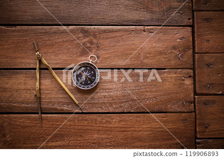 Vintage drawing and navigational Compass on a rustic wooden board Vintage drawing and navigational Compass on a rustic wooden board 119906893
