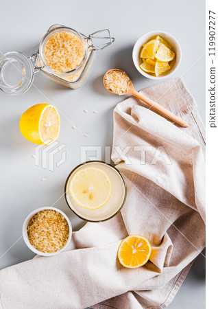 Trendy rice and lemon drink to reduce appetite in a glass on the table top and vertical view Trendy rice and lemon drink to reduce appetite in a glass on the table top and vertical view 119907277