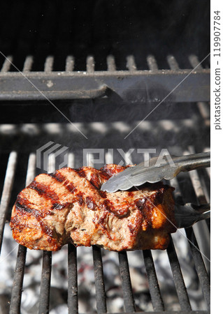 Cooking steak on the grill and coals. Roasting steak in a restaurant. 119907784