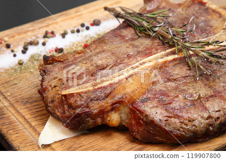 Steak placed on pita bread on a special wooden board. Beef steak on a wooden board. Steak placed on pita bread on a special wooden board. Beef steak on a wooden board. 119907800