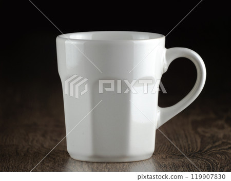 Elegant white mug sits quietly on a rustic wooden surface Elegant white mug sits quietly on a rustic wooden surface 119907830