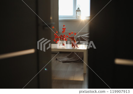 autumn still life with candles, flowers, twigs of red physalis in a vase in a cozy home interior autumn still life with candles, flowers, twigs of red physalis in a vase in a cozy home interior 119907913