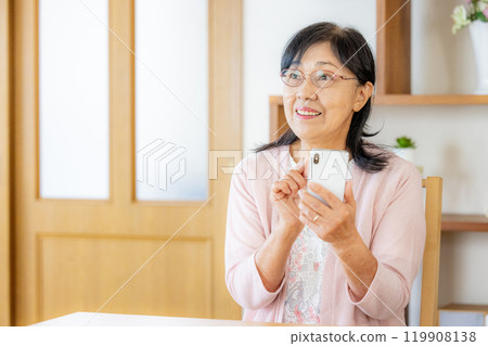 Senior woman looking at her smartphone Senior woman looking at her smartphone 119908138