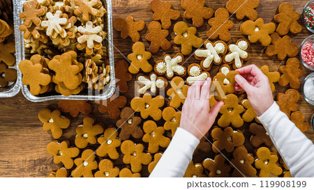 Flat lay. Crafting gingerbread cookie sandwiches with eggnog buttercream, presented on a rustic wooden table for Christmas gifting. Flat lay. Crafting gingerbread cookie sandwiches with eggnog buttercream, presented on a rustic wooden table for Christmas gifting. 119908199