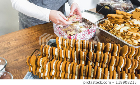 Lovingly homemade gingerbread and sugar cookies, half-dipped in rich chocolate, nestled in decorative Christmas tin boxes perfect for seasonal gifting. Lovingly homemade gingerbread and sugar cookies, half-dipped in rich chocolate, nestled in decorative Christmas tin boxes perfect for seasonal gifting. 119908213