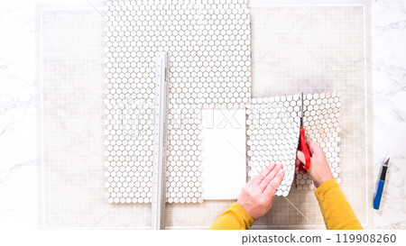 Flat lay. In the process of mounting peel and stick mosaic tiles onto a foam board, perfect for enhancing a food photography studio's aesthetic. 119908260