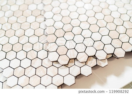 In the process of mounting peel and stick mosaic tiles onto a foam board, perfect for enhancing a food photography studio's aesthetic. 119908292