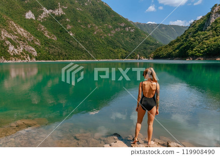 Young Woman in Swimsuit Standing by Mountain Lake 119908490