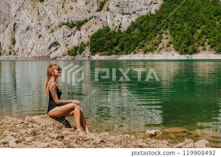 Woman in Swimsuit Sunbathing on Mountain Lake Woman in Swimsuit Sunbathing on Mountain Lake 119908492