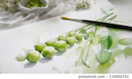 A vibrant watercolor painting features several green peas arranged artistically on textured paper. A paintbrush rests nearby, enhancing the art's creative ambiance 119908701