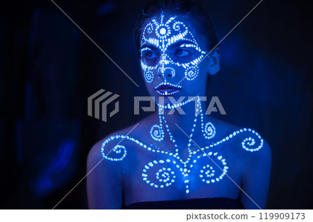 Body art on the body and hand of a girl glowing in the ultraviolet light. Body art on the body and hand of a girl glowing in the ultraviolet light. 119909173
