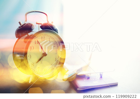 Background with a clock on the table and bokeh in pastel rainbow colors. Time for rest and travel. 119909222