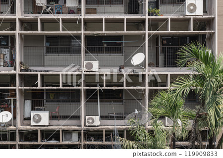 Multistory old concrete apartment building with group of windows on balconies. 119909833