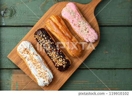 Assorted eclairs on a pastel top view Traditional French dessert 119910102