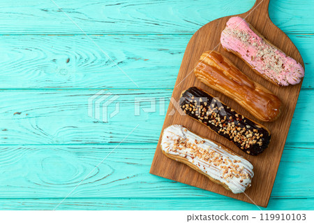 Assorted eclairs on a pastel top view Traditional French dessert 119910103