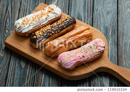 Assorted eclairs on a pastel top view Traditional French dessert 119910104