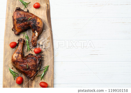 Grilled chicken legs with tomatoes and salad . Top view Grilled chicken legs with tomatoes and salad . Top view 119910158