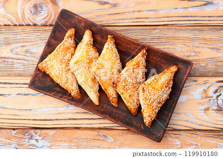 Homemade triangle puff pastry with meat on rustic background . Samosa 119910180