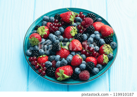 Mix of ripe colorful berries in bowl photography . Blueberry , strawberry , raspberry , blackberry and red currant . Top view 119910187
