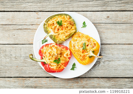 Baked stuffed pepper ( paprika ) with rice , carrot and meat . Top view on rustic background 119910221