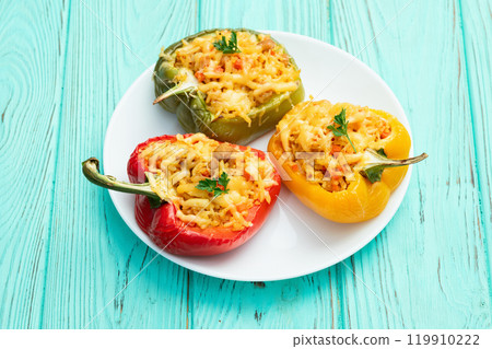 Baked stuffed pepper ( paprika ) with rice , carrot and meat . Top view on rustic background 119910222