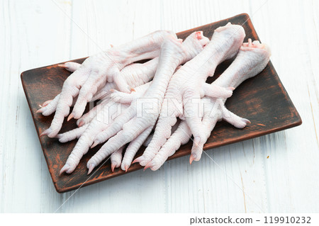 Raw chicken foot ( paws ) Top view on rustic background Raw chicken foot ( paws ) Top view on rustic background 119910232