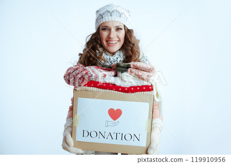 smiling stylish woman in sweater, mittens, hat and scarf on 119910956