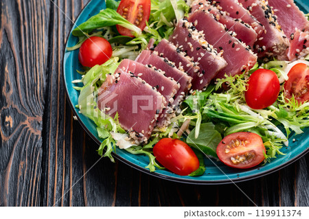 Salad with raw tuna , sesame and cherry tomatoes photography . Top view 119911374