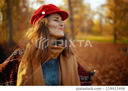 cheerful woman in red hat with scarf 119911406