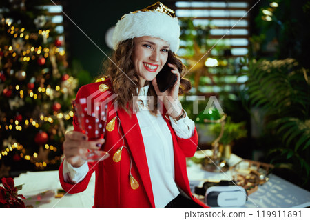 smiling talking on phone in green office with Christmas tree 119911891