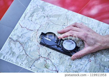 Woman orienting herself with a map and a compass . Woman orienting herself with a map and a compass . 119911958