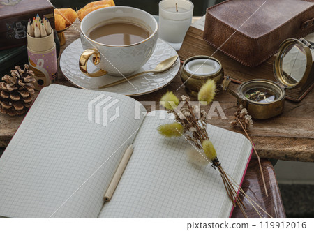 Refreshing with Hot coffee in ceramic cup served with Fresh milk on old wooden worktable with notebook and pencil. Refreshing with Hot coffee in ceramic cup served with Fresh milk on old wooden worktable with notebook and pencil. 119912016